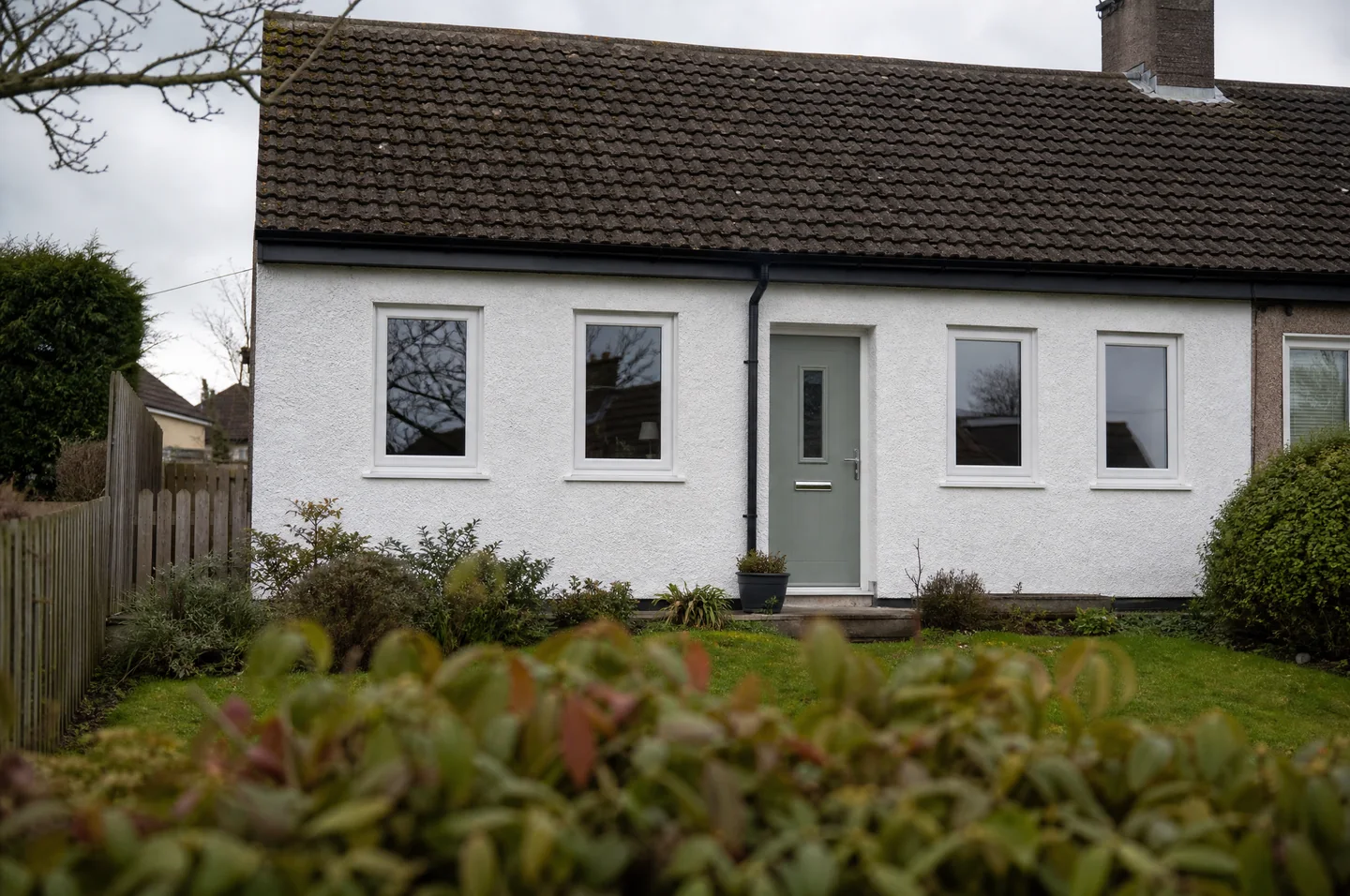 Traditional UK home with a coloured front door and crisp white windows